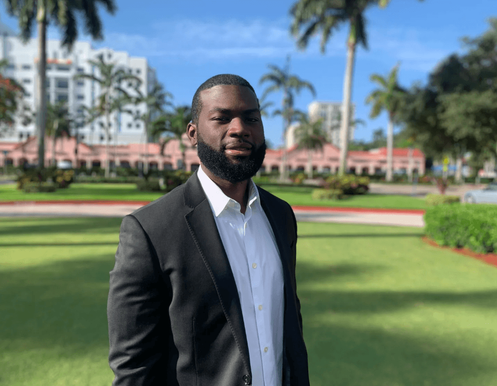 Investor in a suit standing on a resort lawn in Boca Raton